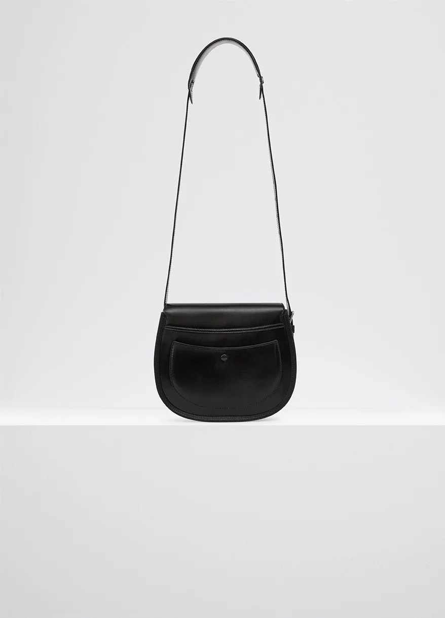Lemaire cartridge sport bag in black vegetable-tanned leather, product shot, full hanging view curved shape, flap pocket