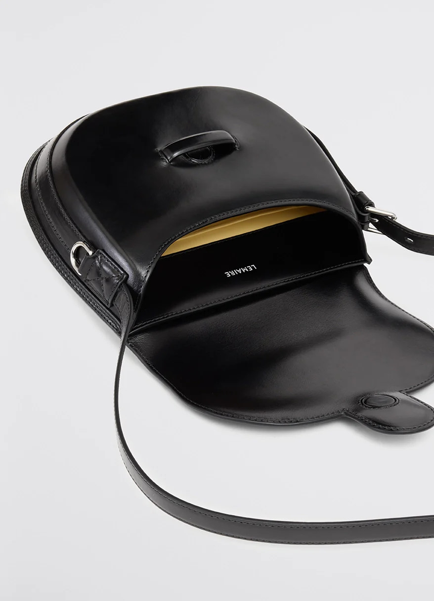 Lemaire cartridge sport bag in black vegetable-tanned leather, product shot, open top detail shot interior pocket and clasp