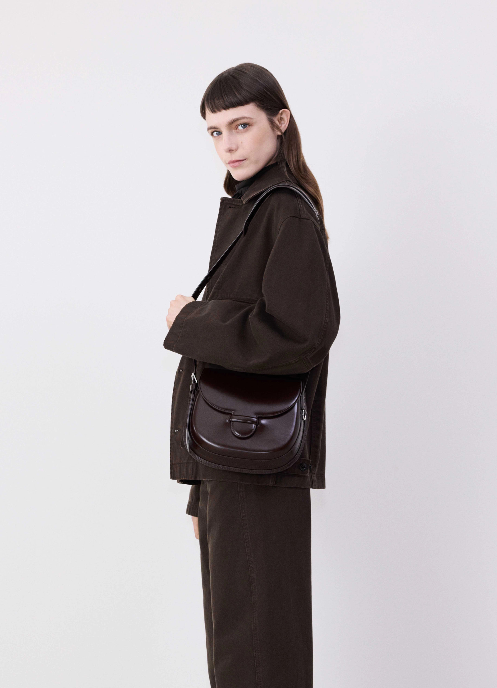 Lemaire cartridge sport bag in smooth vegetable-tanned leather, model shot, side view crossbody worn