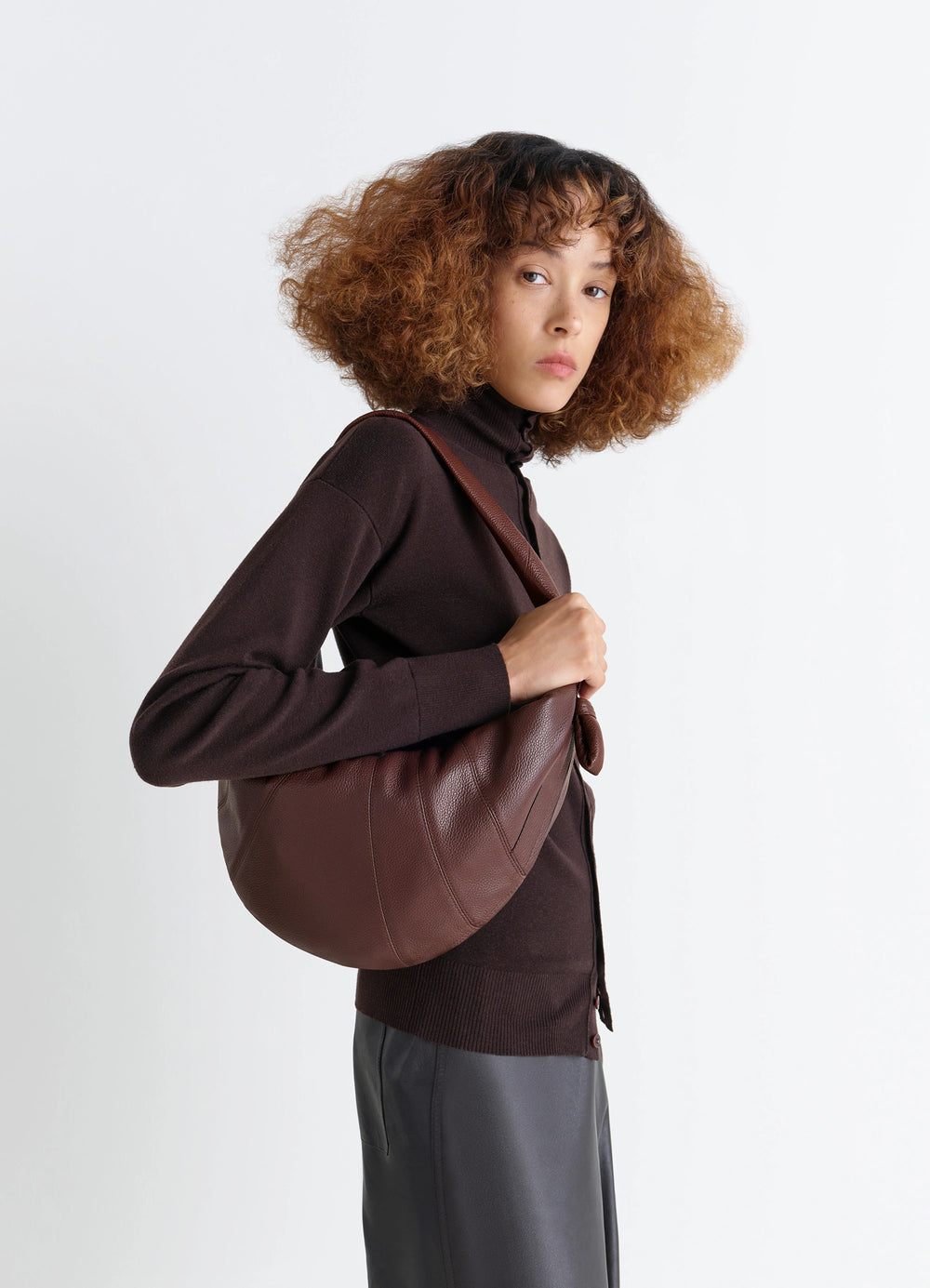 Fortune Croissant Bag in Grained Leather, model shot, Side view Knotted elements