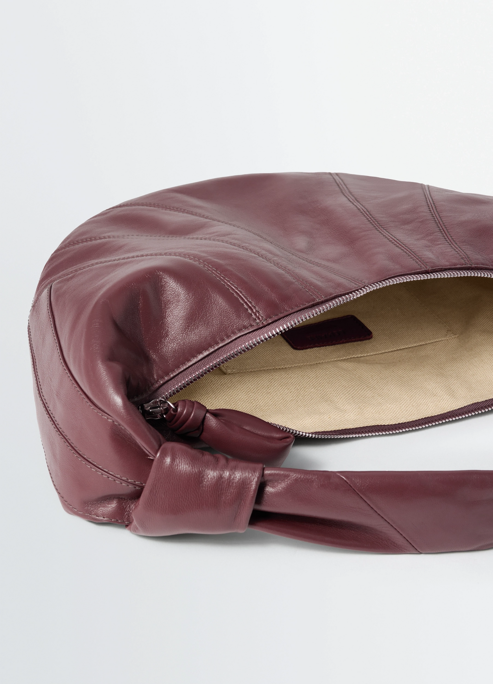 Fortune croissant bag in leather, product shot, top angled view visible stitching, lined interior
