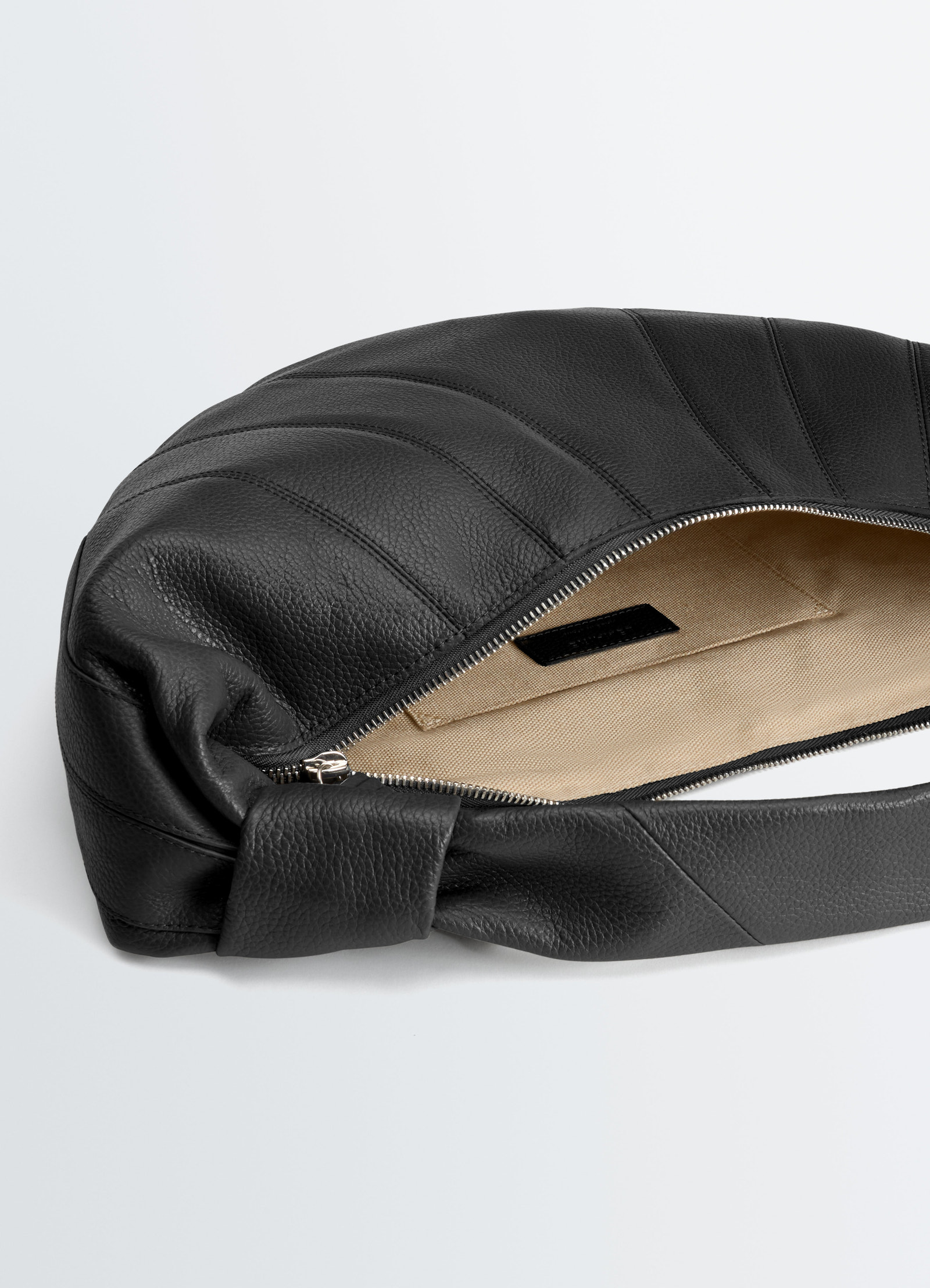 Fortune croissant bag in black leather with beige fabric lining by lemaire close-up detail of open zipper