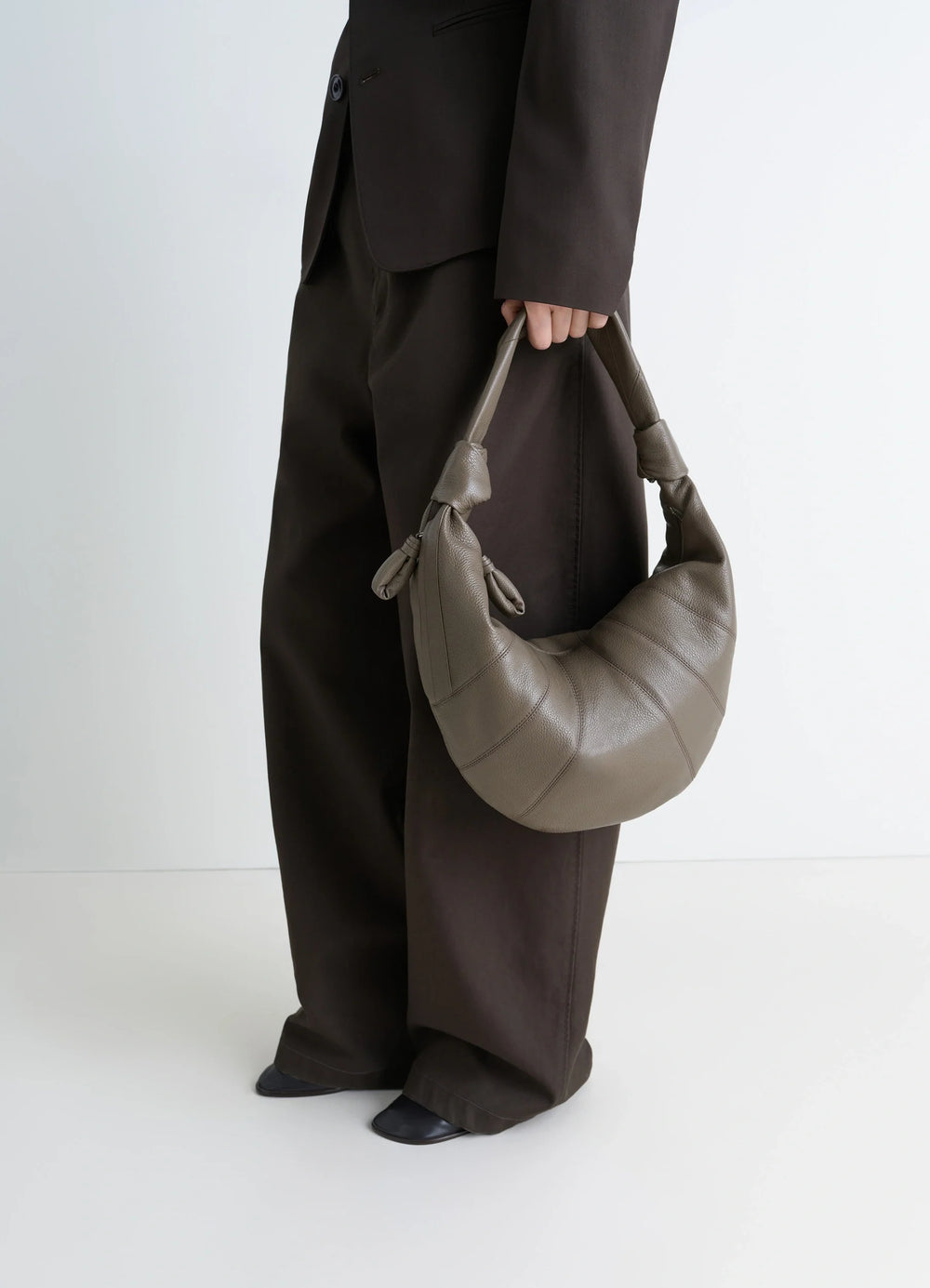 Fortune Croissant Bag in Grained Leather, model shot, Side view Half-moon shape, knotted