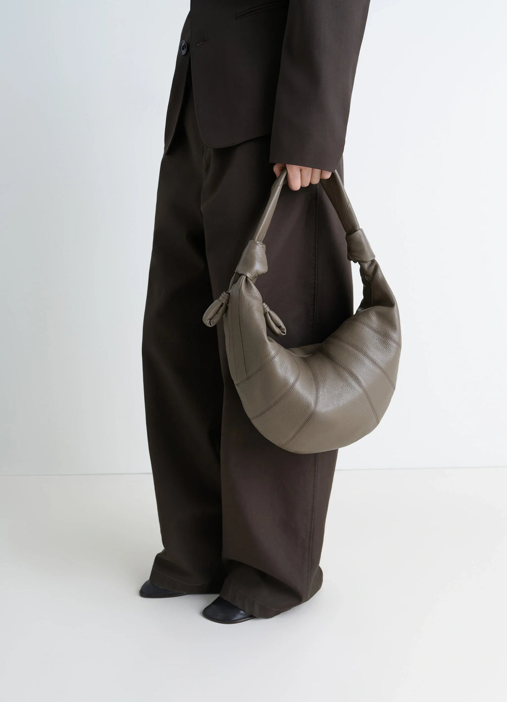 Fortune Croissant Bag in Grained Leather, model shot, Side view Half-moon shape, knotted