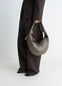 Fortune Croissant Bag in Grained Leather, model shot, Side view Half-moon shape, knotted