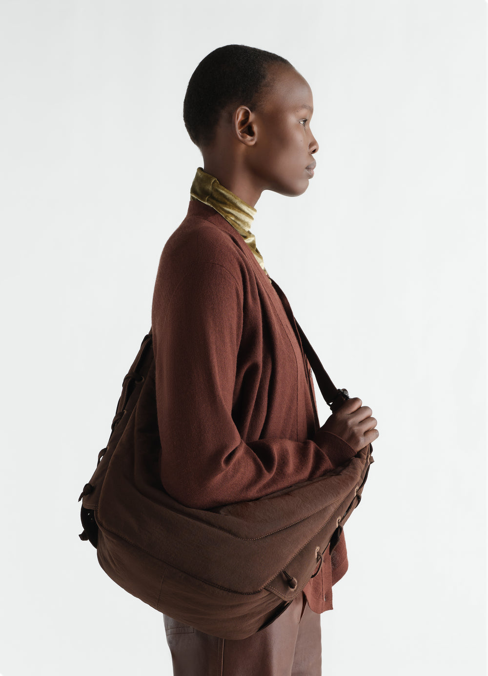 Medium soft game bag in brown nylon canvas LEMAIRE worn by model side view with leather details