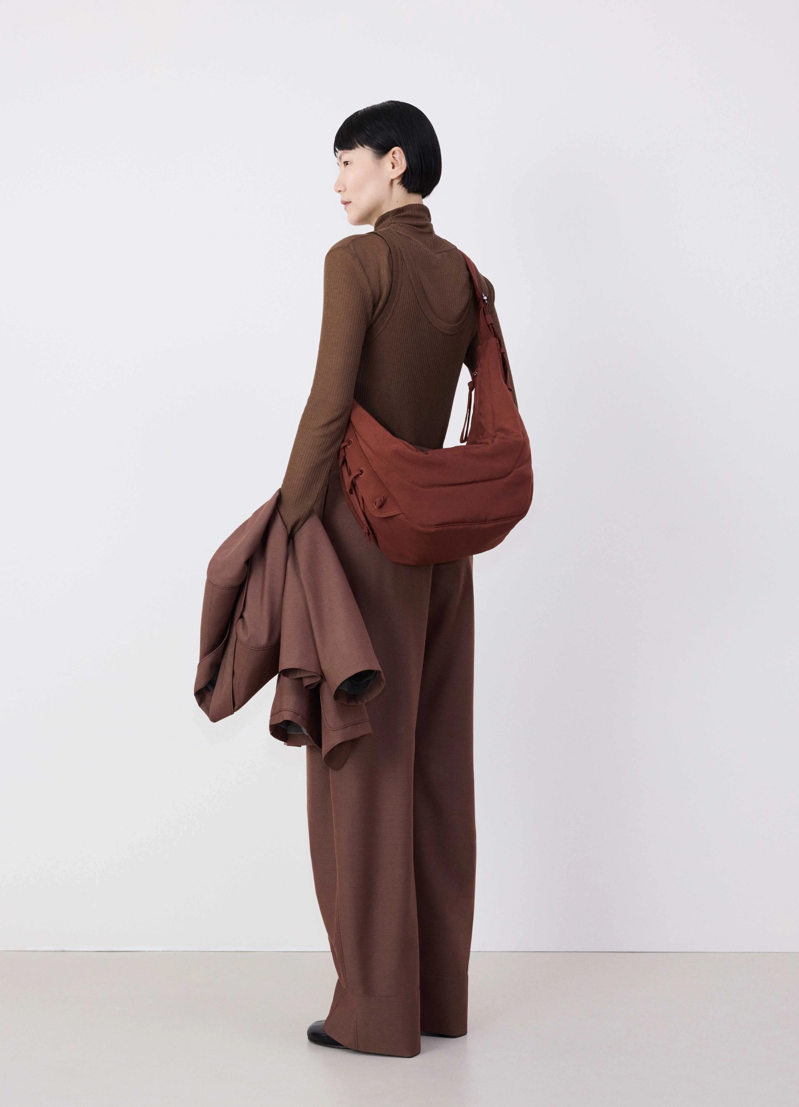 Medium soft game bag in fluffy-nylon canvas, model shot, back view sling strap worn