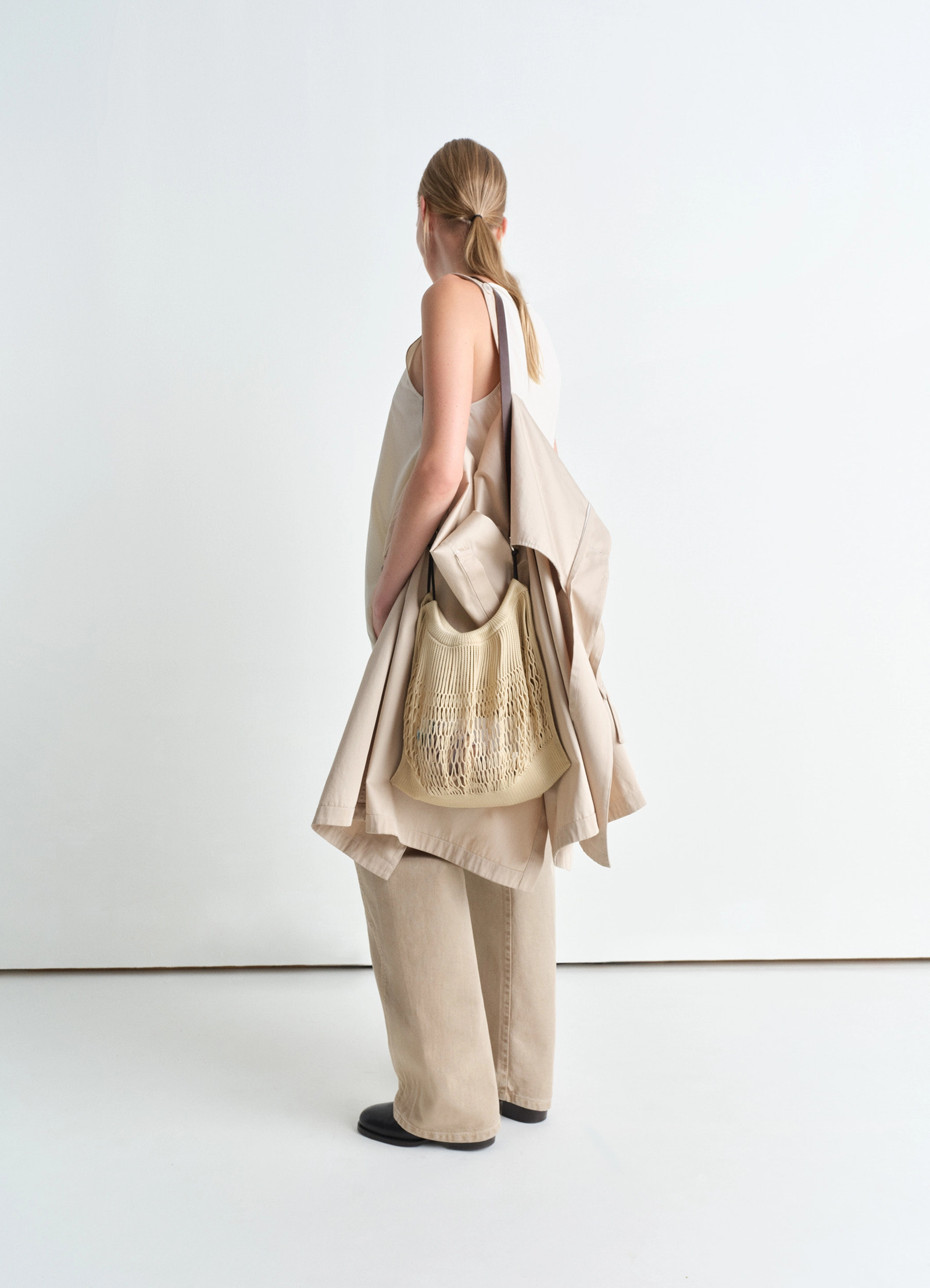 Lemaire large crossbody filt net ba in delicate nylon, dark chocolate leat, model shot, back view worn as cross-body