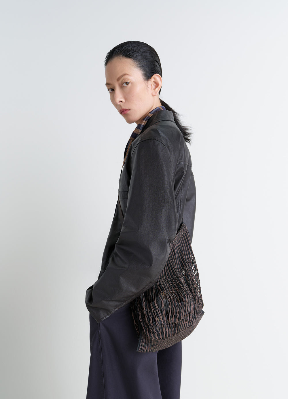 Lemaire Large Crossbody Filt Net Sh in Nylon mesh, vegetable-tanned leathe, model shot, side view worn slouched casual style