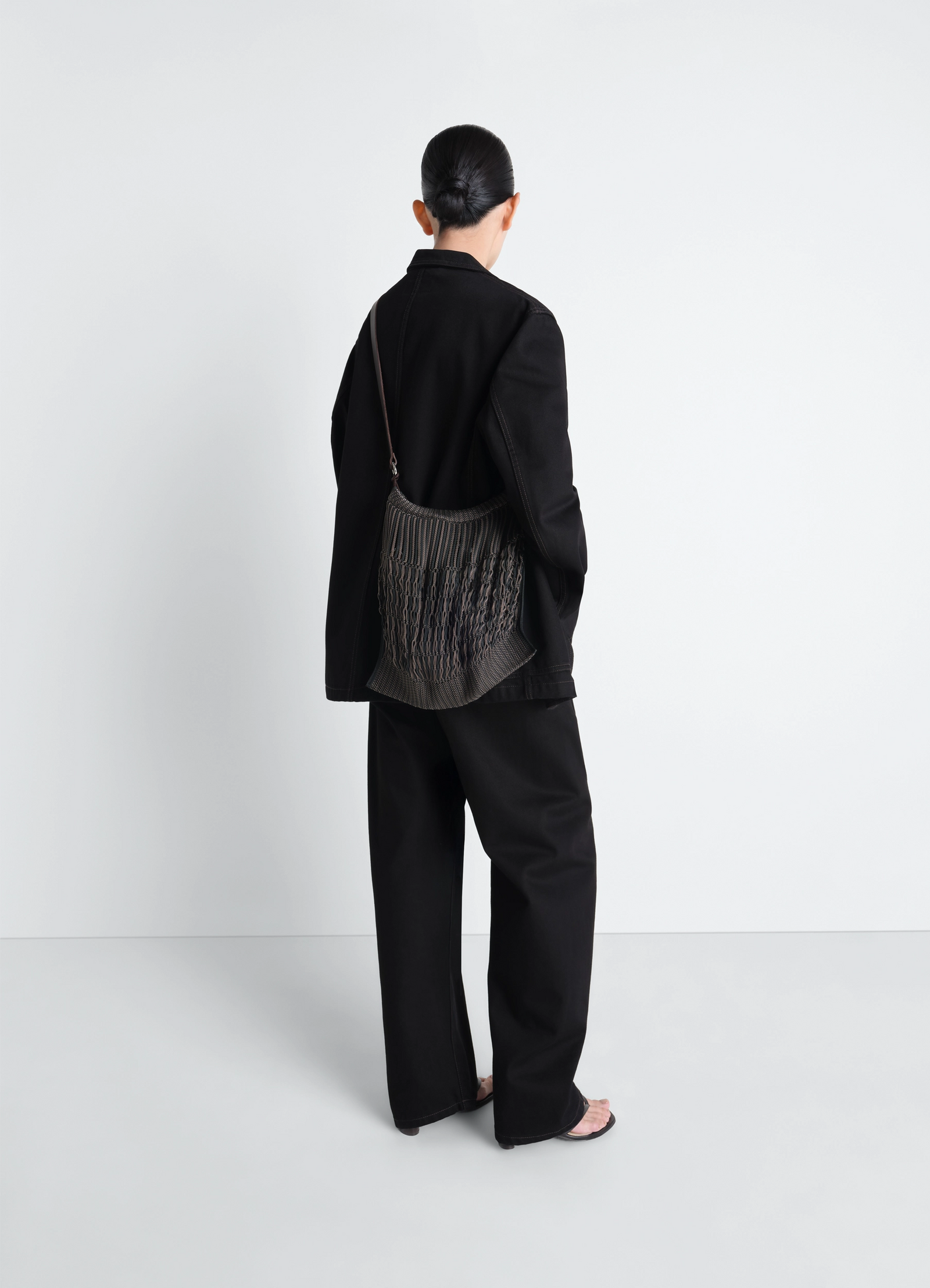 Lemaire large crossbody filt net in black nylon mesh, leather, model shot, back view crossbody worn by model