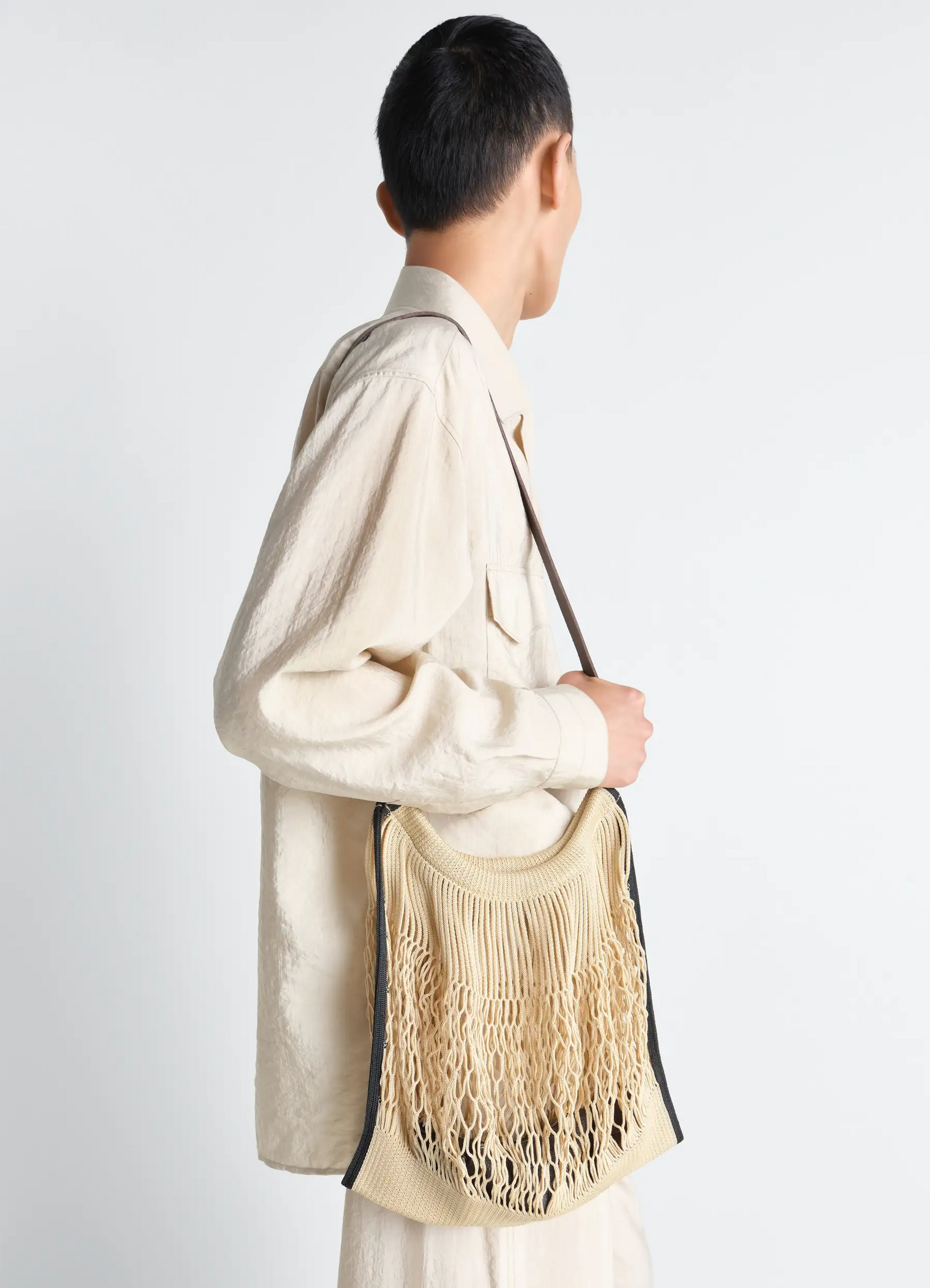 Large crossbody filt net shopping b in nylon mesh and leather, model shot, side view worn crossbody