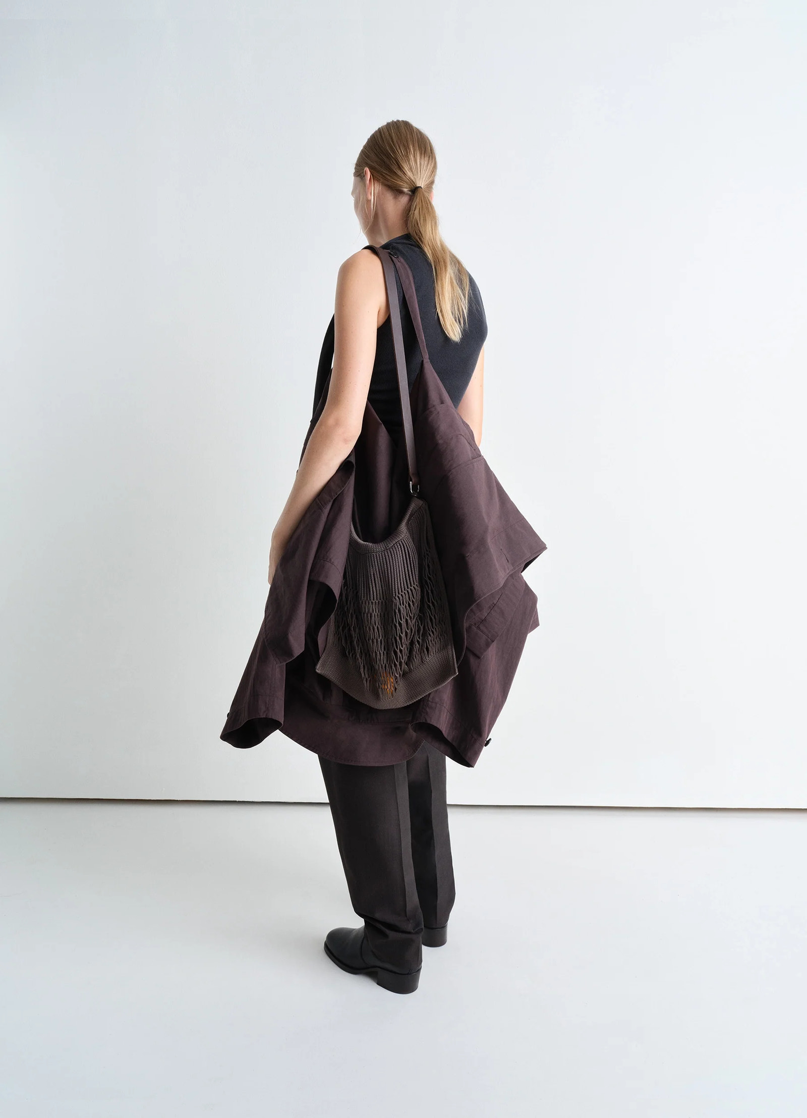 Lemaire large crossbody filt net ba in dark chocolate, nylon, leather, model shot, back view crossbody, worn