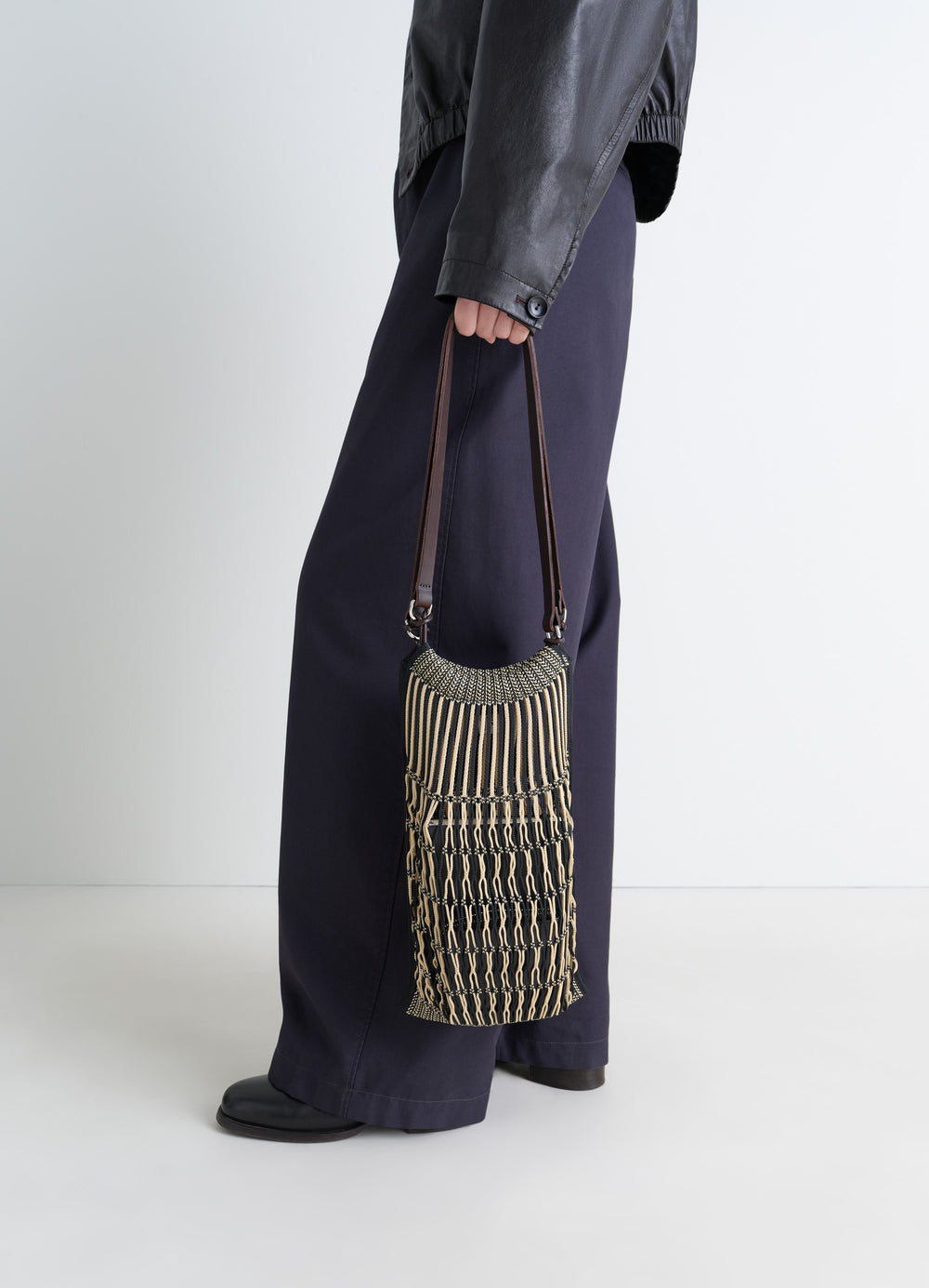 MEDIUM FILT NET SHOPPING BAG in nylon mesh vegetable-tanned leather, model shot, side view held by person