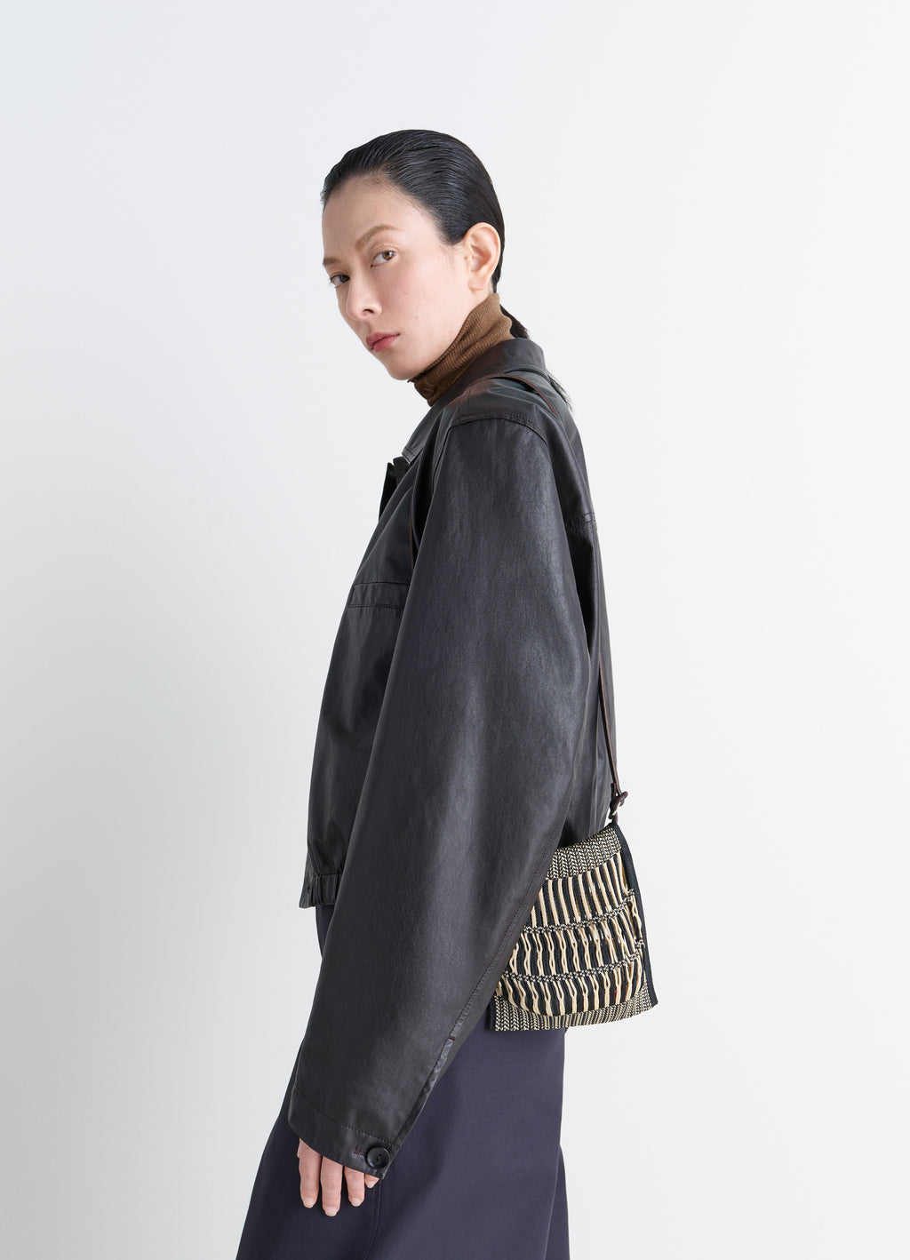 MINI CROSSBODY FILT NET BAG in nylon mesh, vegetable-tanned leathe, model shot, three-quarter view carried on shoulder
