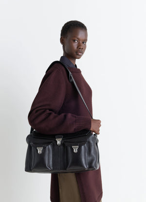 Lemaire Week-End Gear Bag in Glossy Vegetable-Tanned Leather, model shot, Side view Signature flap closure