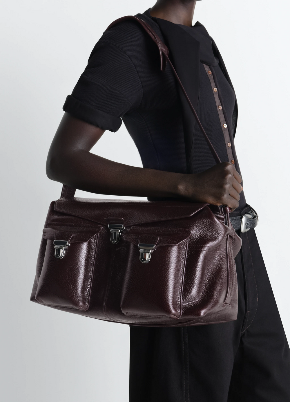 Lemaire Week-End Gear Bag in Glossy Vegetable-Tanned Leather, model shot, side view shoulder carry with strap