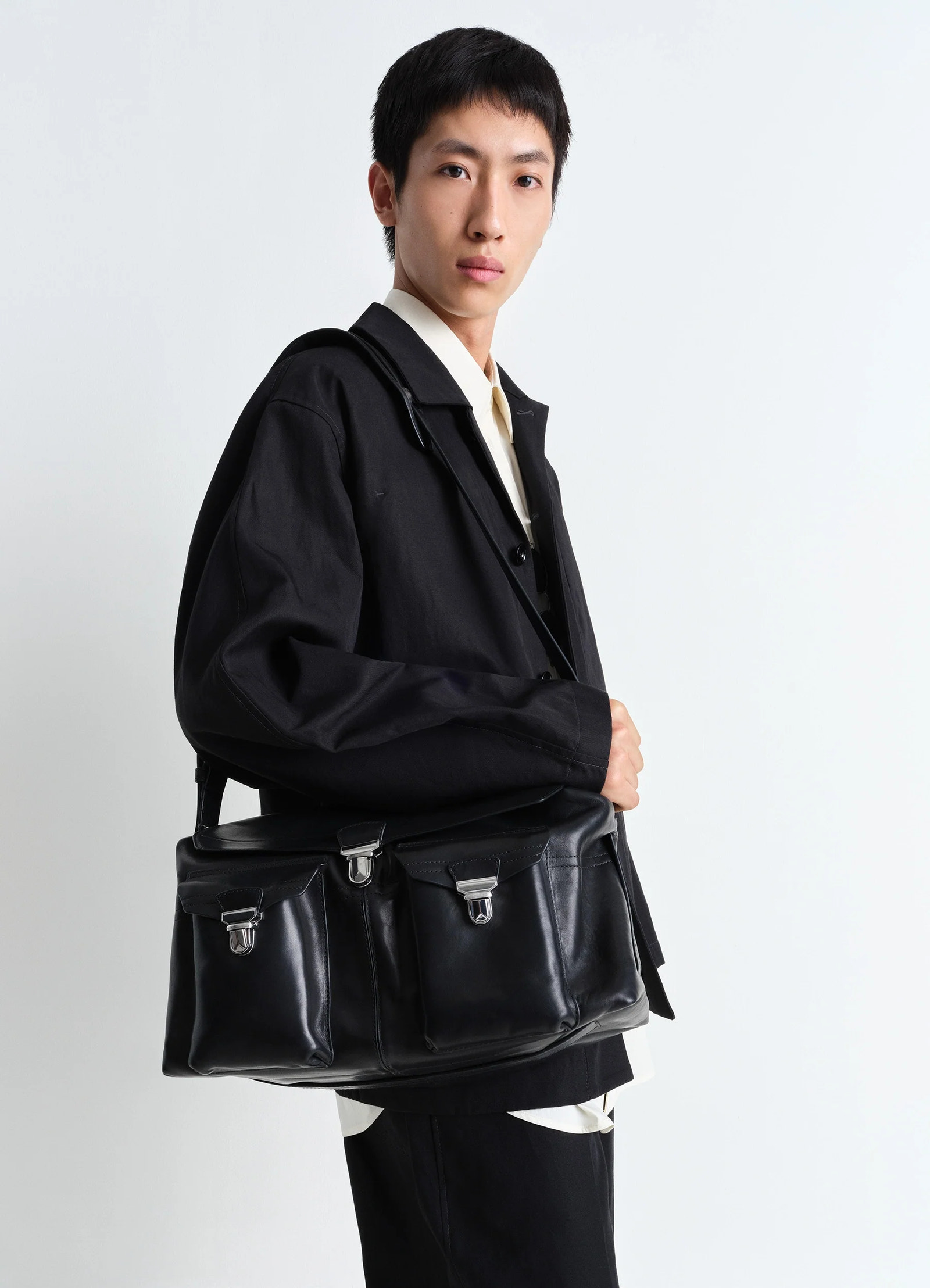 Week-end gear bag in vegetable-tanned nappa leather, model shot, angled shoulder view worn on shoulder