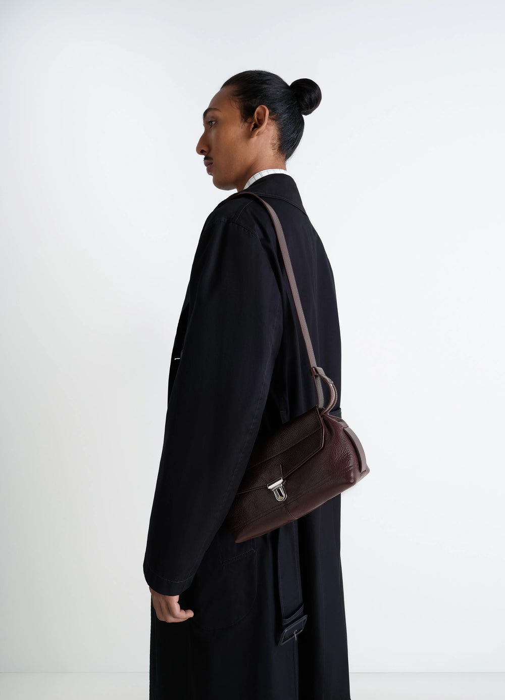 Lemaire Small Gear Bag in Glossy Vegetable-Tanned Leather, model shot, side view flap closure with clip clasp