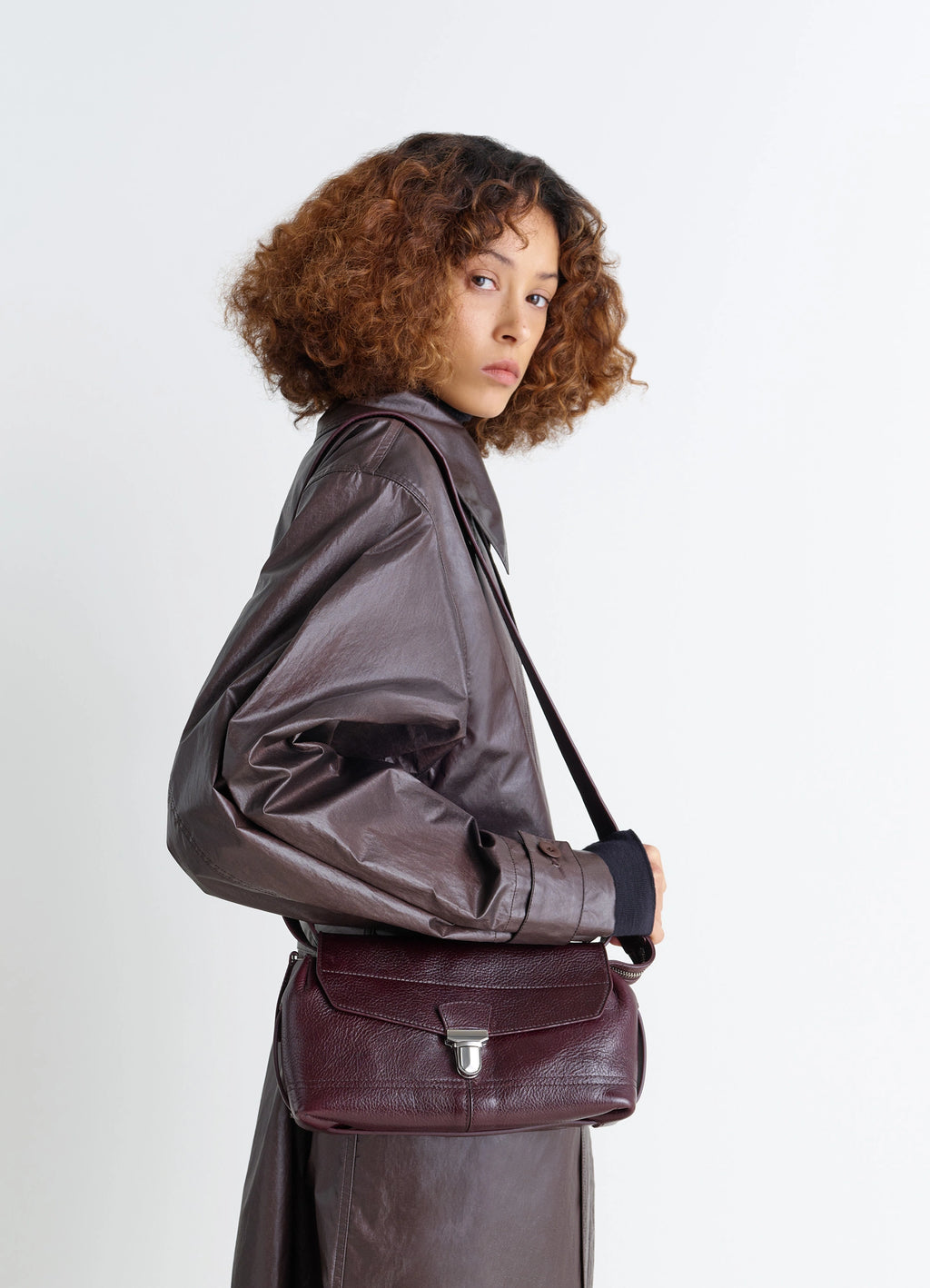Lemaire Small Gear Bag in Glossy Vegetable-Tanned Leather, model shot, three-quarter view crossbody wear style
