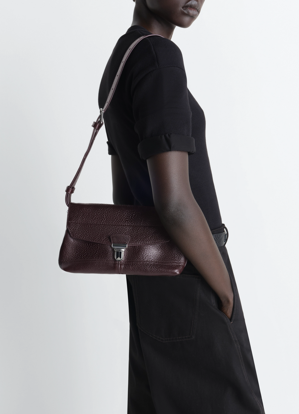 Lemaire Small Gear Bag in Glossy Vegetable-Tanned Leather, model shot, side view with strap curved bottom edge