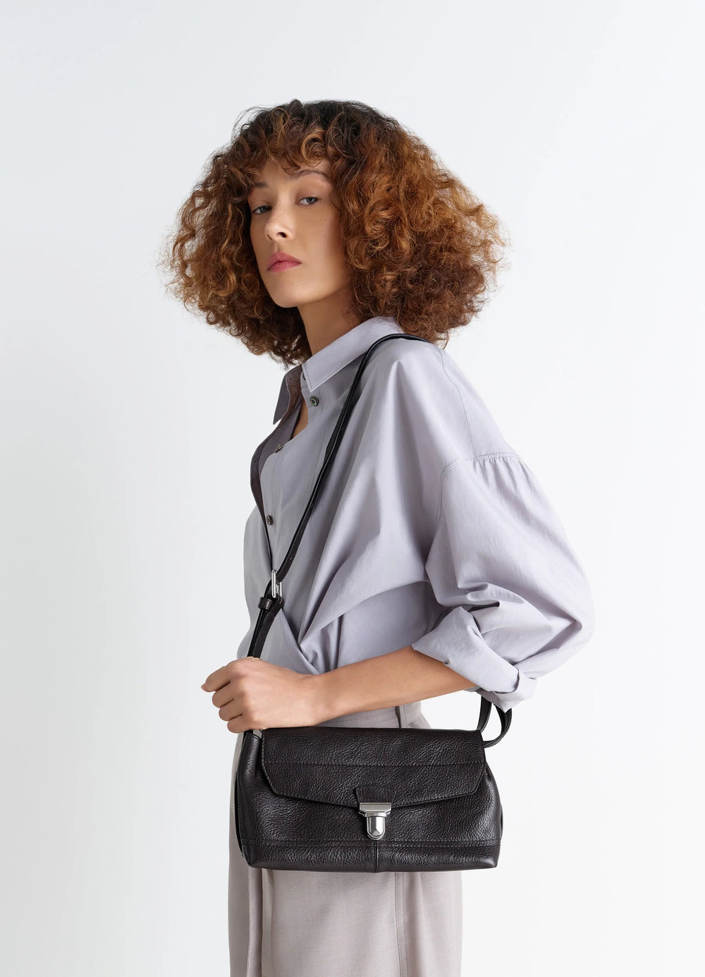 Lemaire Small Gear Bag in Glossy Vegetable-Tanned Leather, model shot, three-quarter view shoulder carry styling