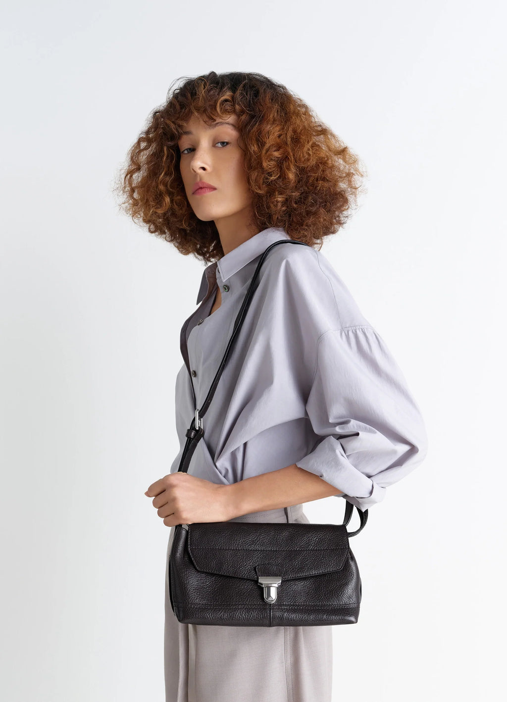 Lemaire Small Gear Bag in Glossy Vegetable-Tanned Leather, model shot, three-quarter view shoulder carry styling