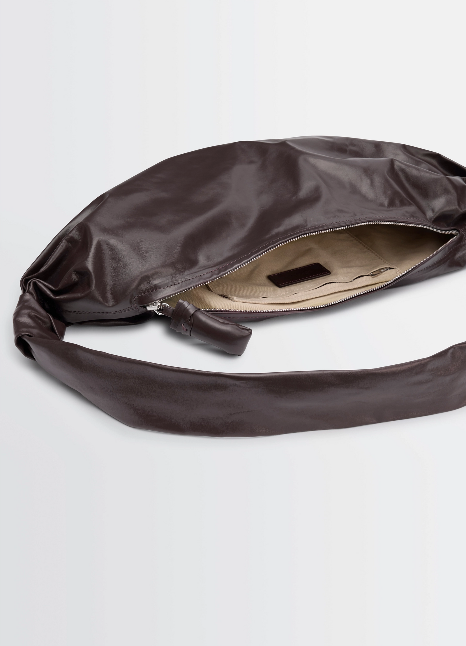 Medium soft croissant bag in paper leather, product shot, top detail shot open zipper interior view