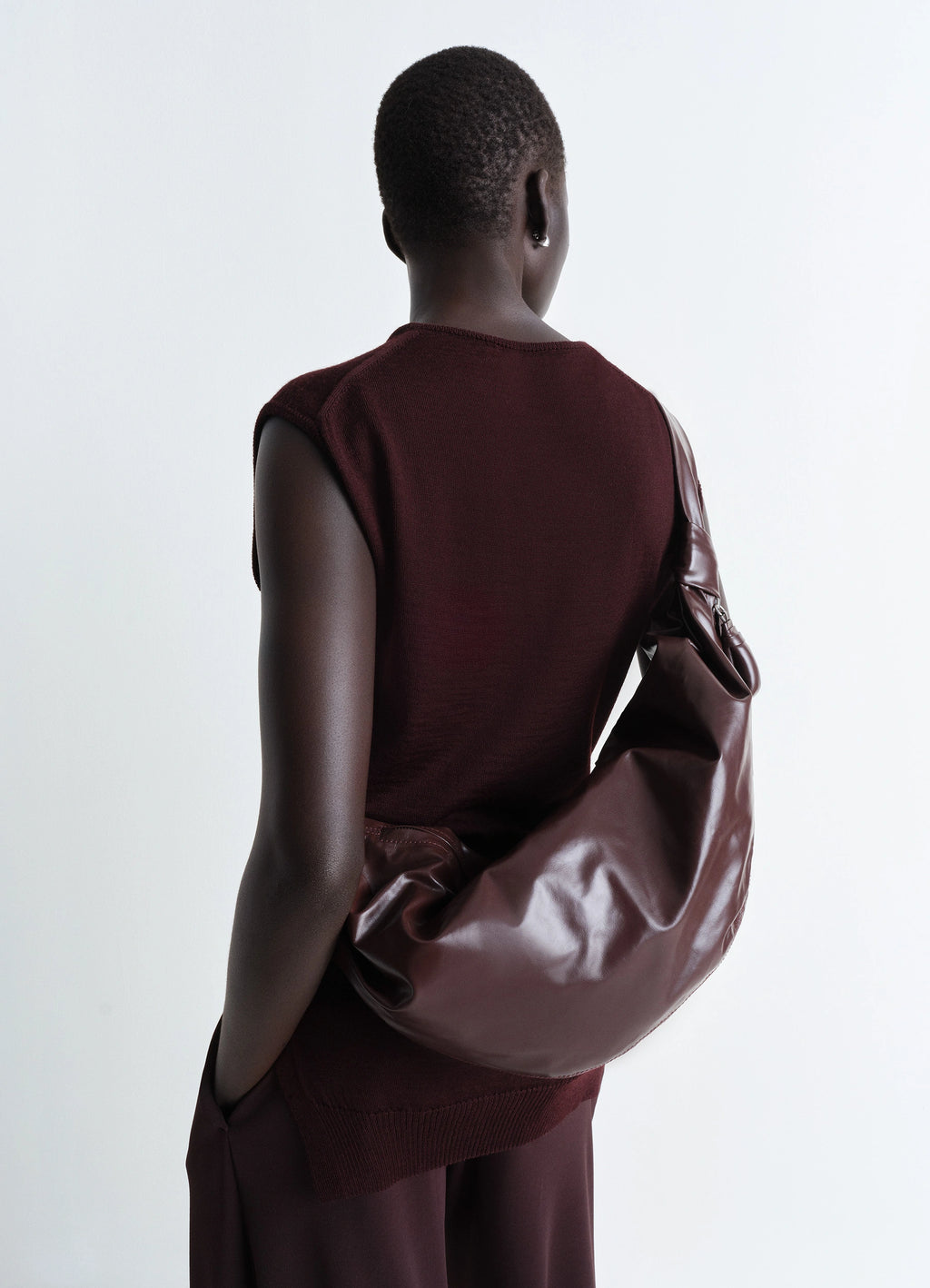 Lemaire Medium Soft Croissant in paper-effect leather, model shot, back view curved shape, knotted