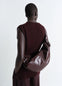 Lemaire Medium Soft Croissant in paper-effect leather, model shot, back view curved shape, knotted
