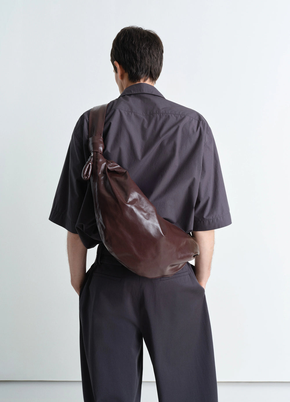 Lemaire Medium Soft Croissant in paper-effect leather, model shot, over-the-shoulder slouchy structure