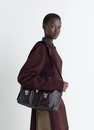 Lemaire Medium Gear Bag in Glossy Vegetable-Tanned Leather, model shot, Side view Adjustable shoulder strap