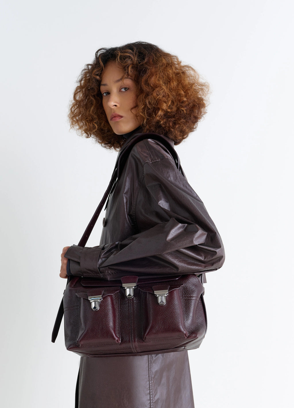Lemaire Medium Gear Bag in Glossy Vegetable-Tanned Leather, model shot, Side view Adjustable shoulder strap