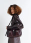 Lemaire Medium Gear Bag in Glossy Vegetable-Tanned Leather, model shot, Side view Adjustable shoulder strap