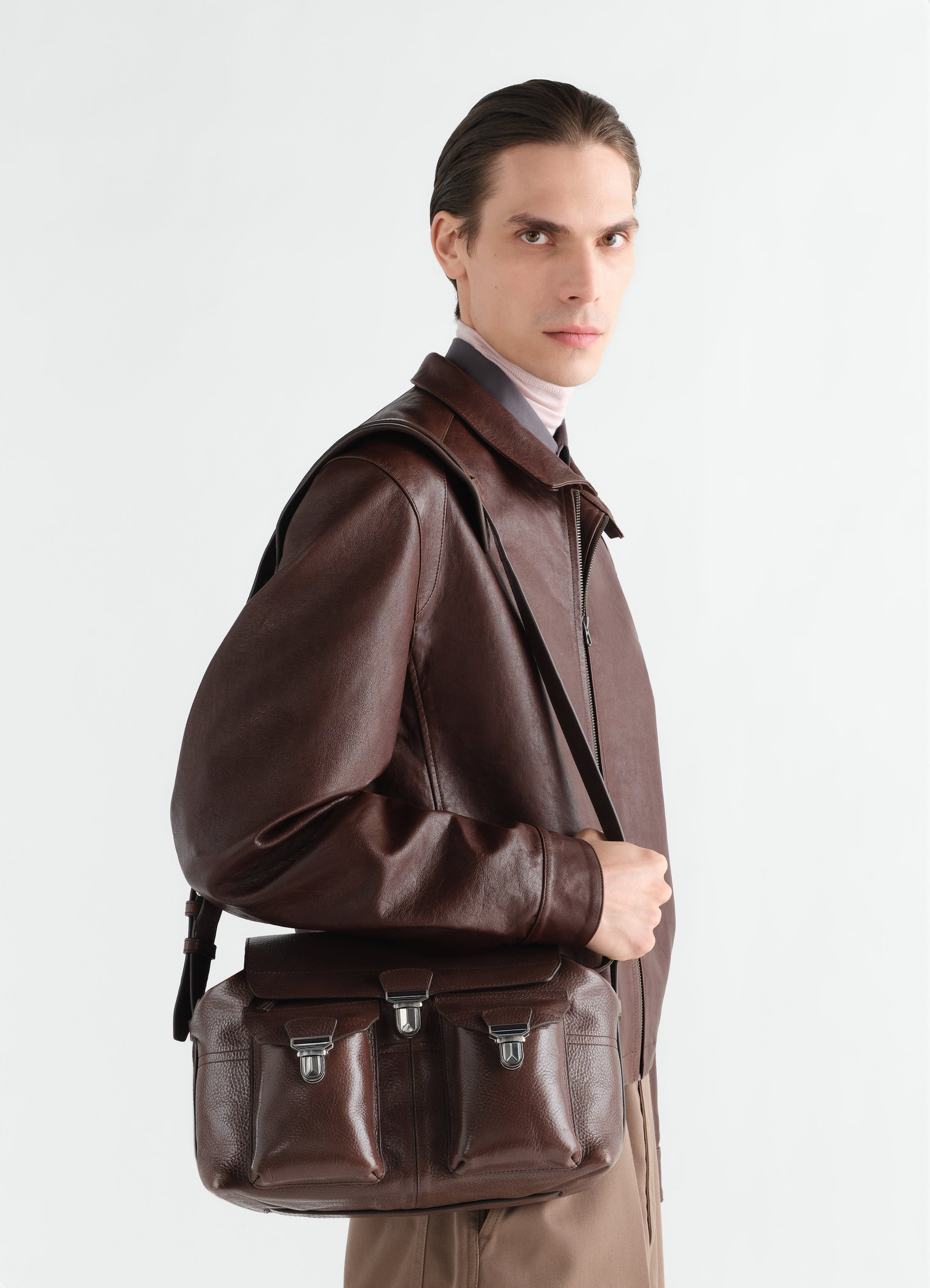 Medium brown leather gear bag with front pockets worn by model side view lemaire