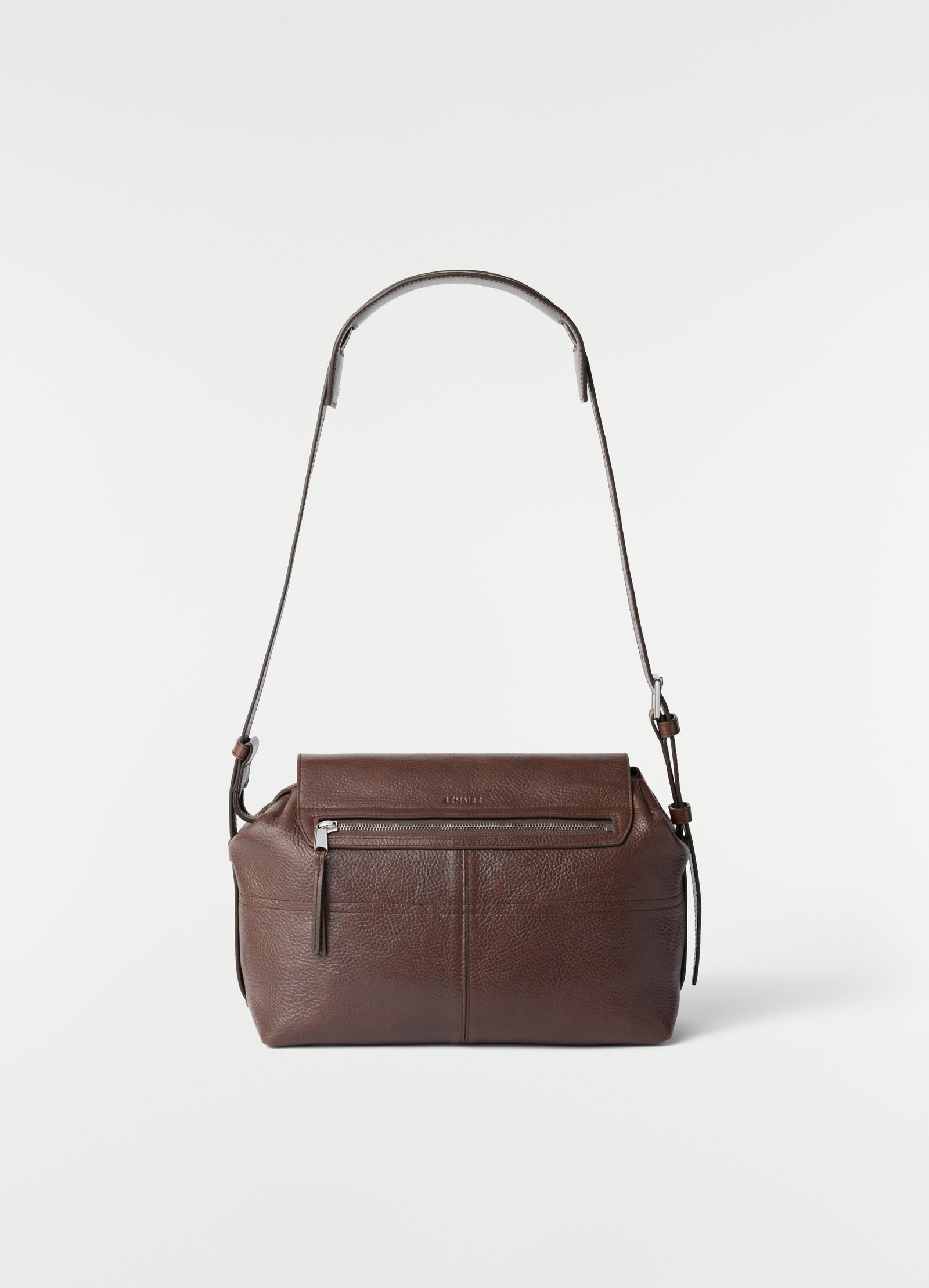 Medium brown leather gear bag medium with adjustable strap and front zip pocket by lemaire on plain white background