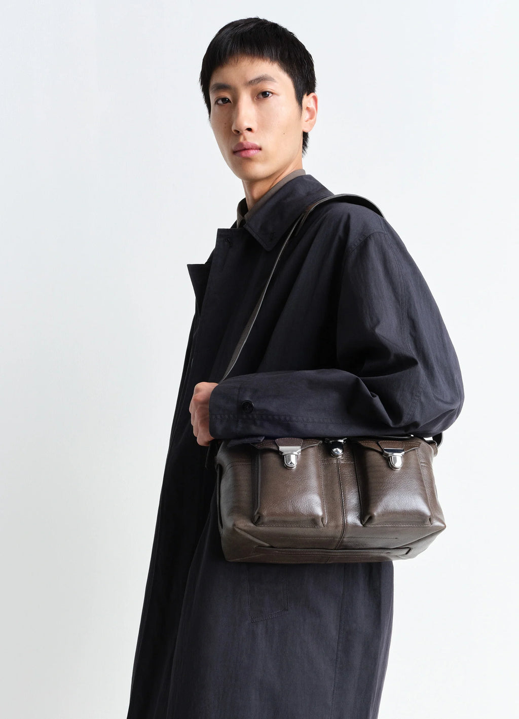 Lemaire Medium Gear Bag in Smooth Irregular Grained Leather, model shot, shoulder view clasped front flap
