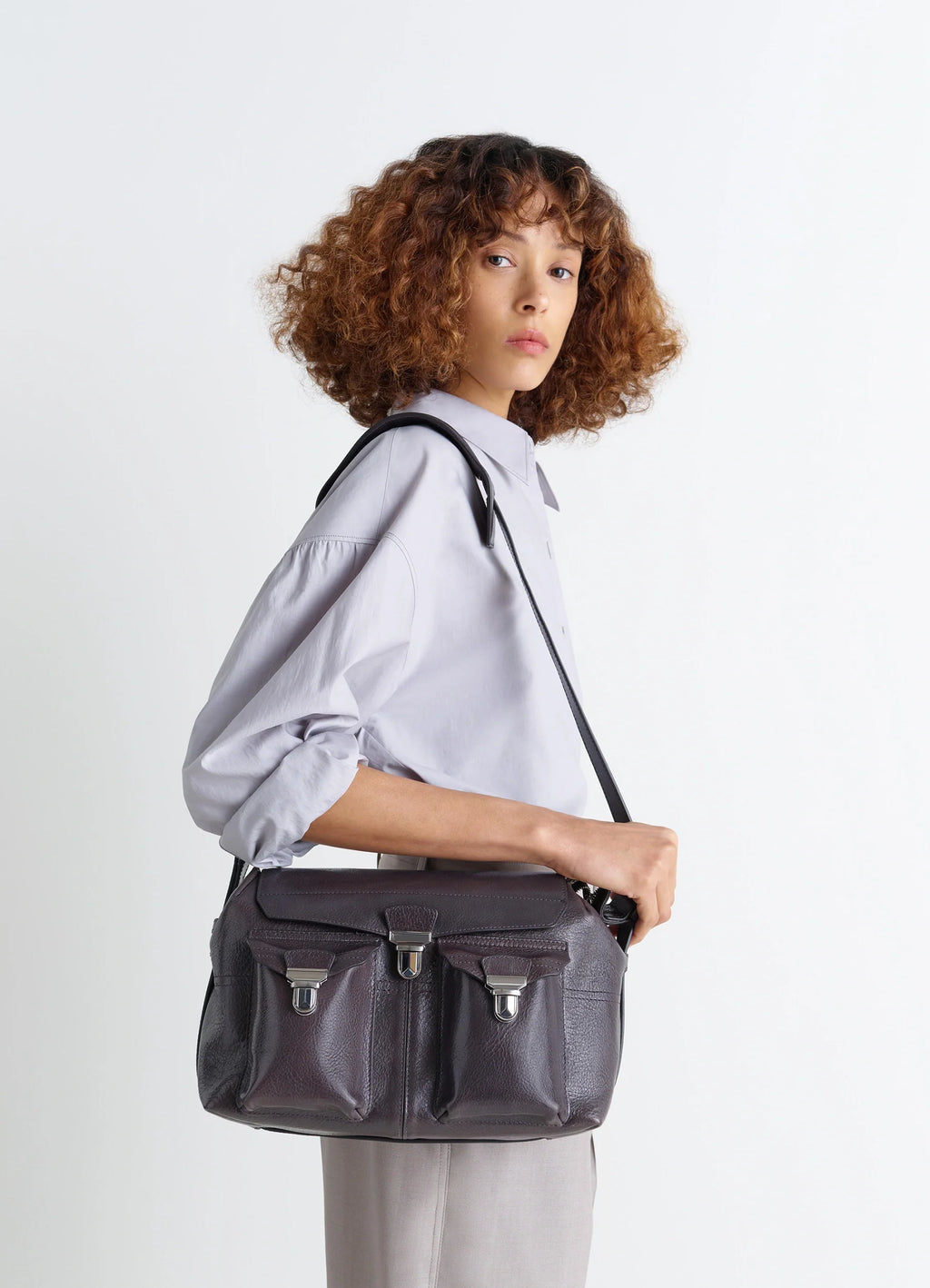 Lemaire Medium Gear Bag in Glossy Vegetable-Tanned Leather, model shot, Side view Adjustable shoulder strap