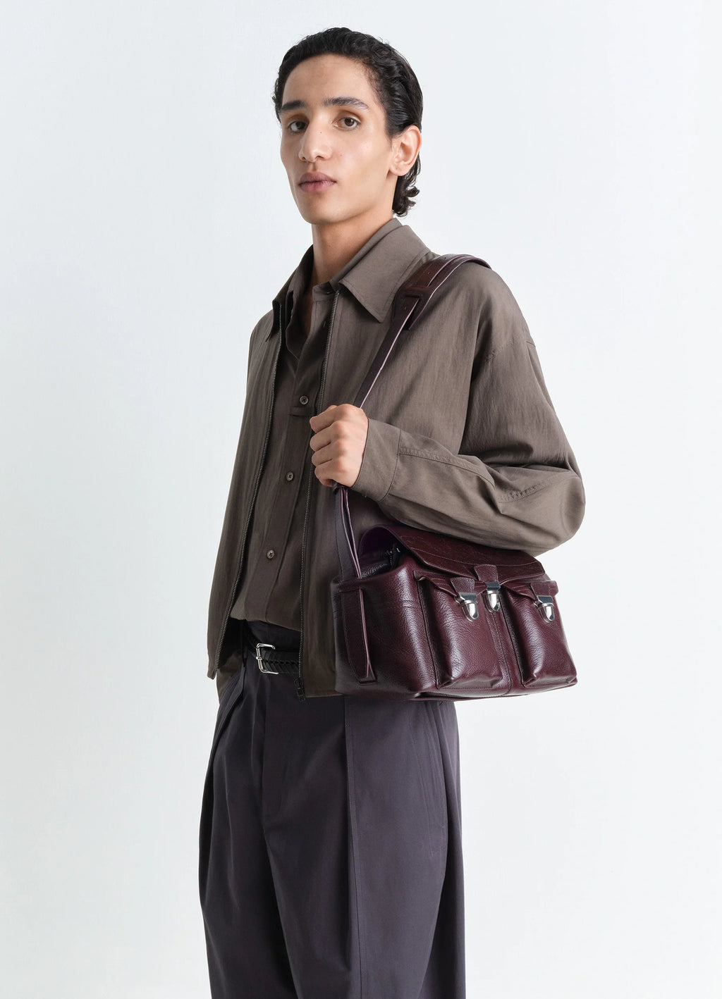 Lemaire Medium Gear Bag in Glossy Vegetable-Tanned Leather, model shot, shoulder view carried on shoulder