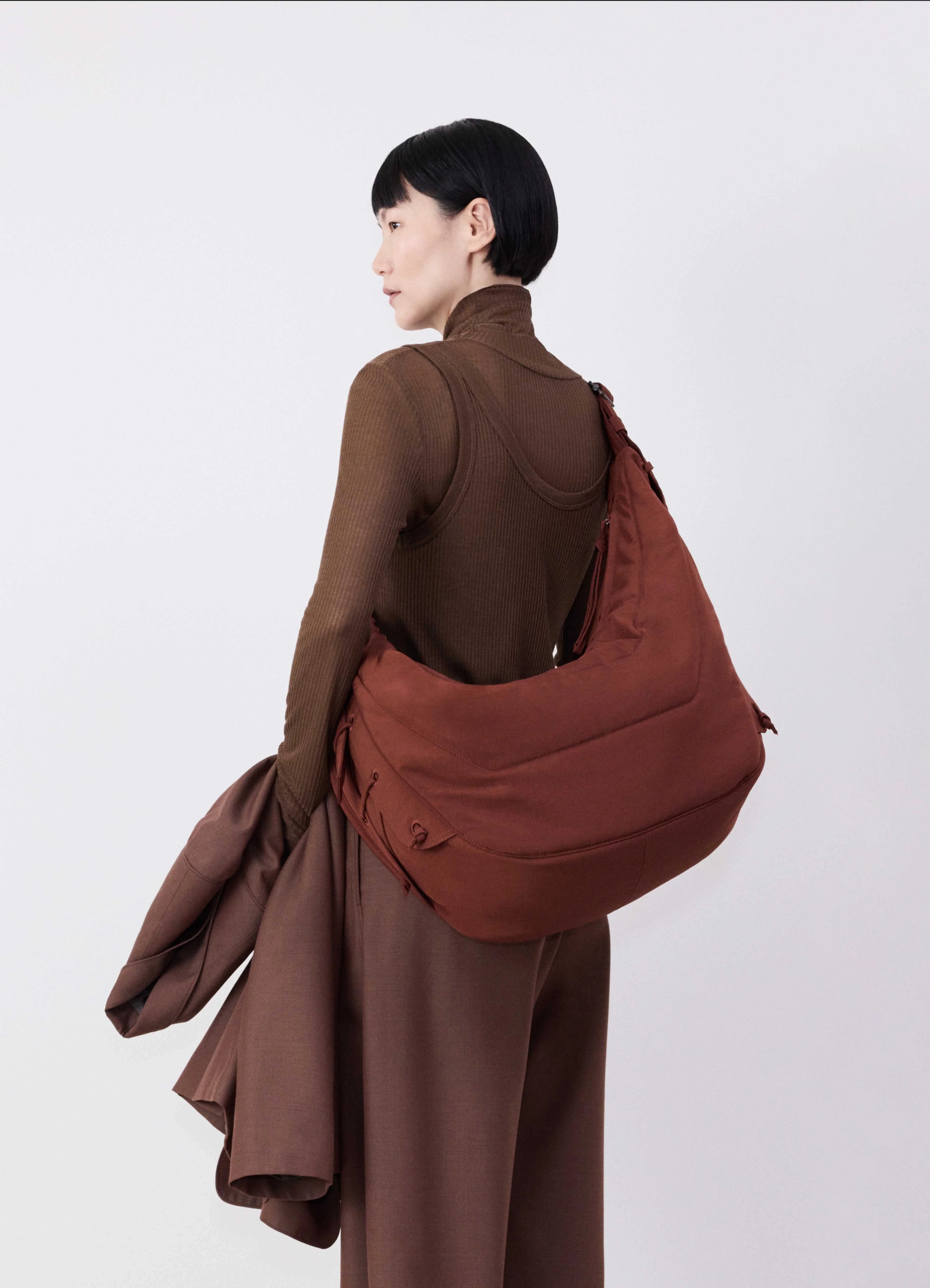 Large soft game bag in fluffy-nylon canvas, model shot, back view slouchy shoulder worn