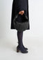 Mini Fortune Croissant Bag in Black Grained Leather, model shot, Side view Knotted handle, half-moon shape