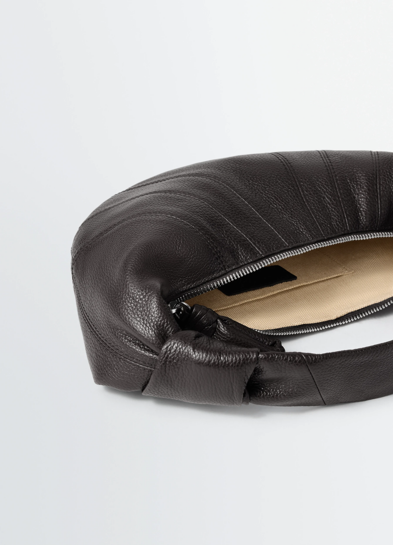Mini fortune croissant bag in grained leather, product shot, top angle zipper detail focus