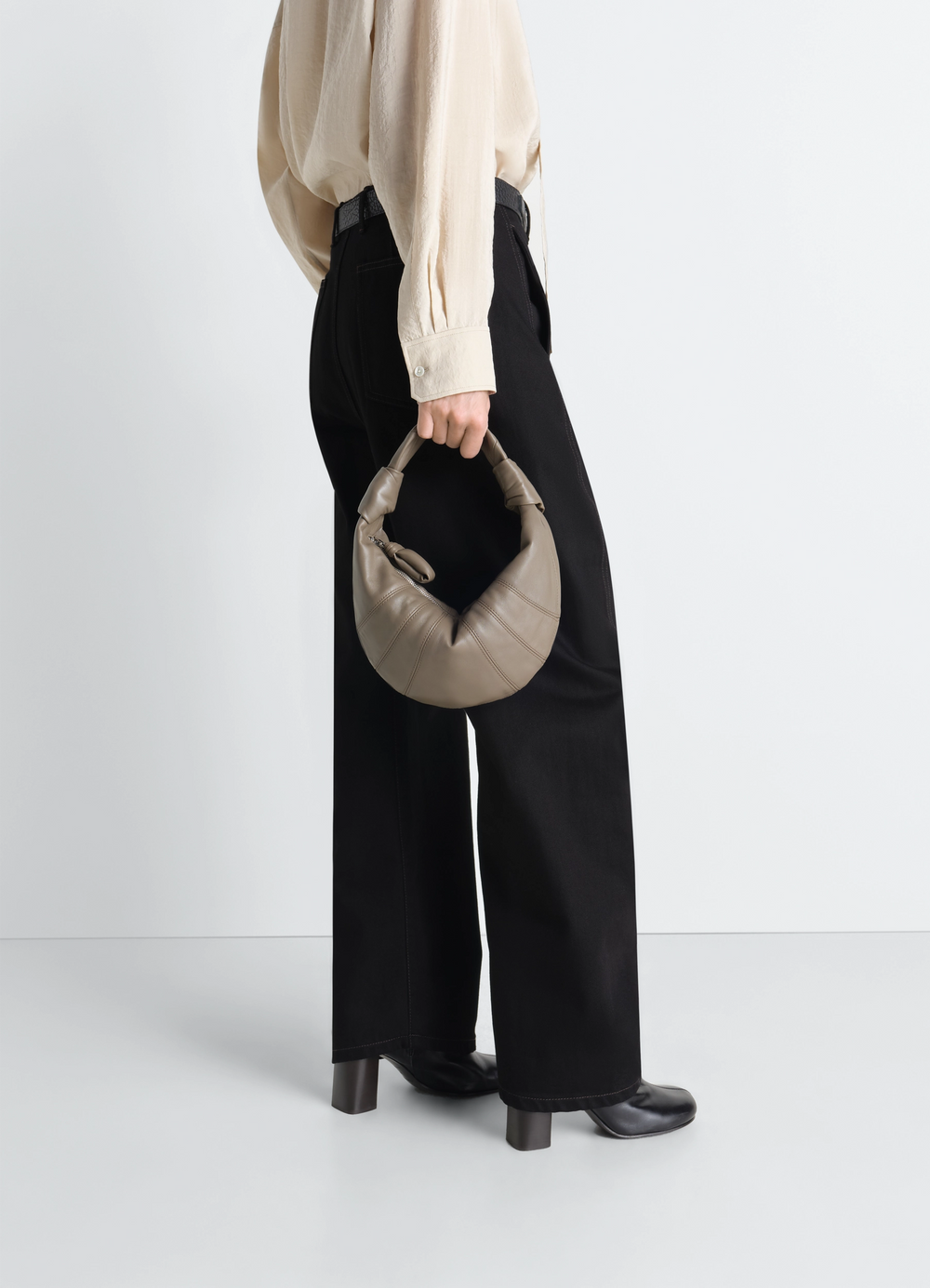 Mini Fortune Croissant Bag in Leather, model shot, side view crescent shape, handheld