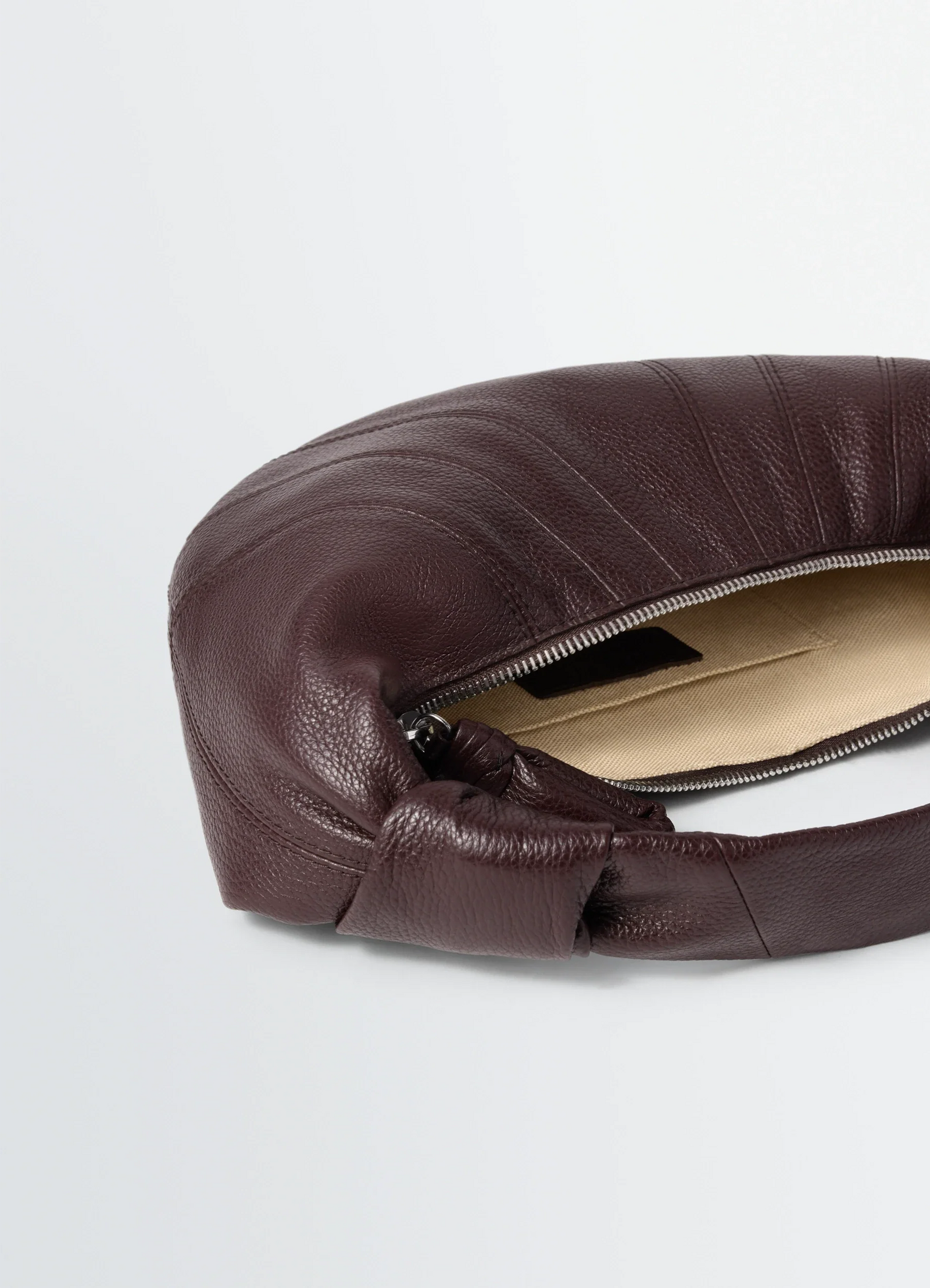 Mini fortune croissant bag in grained leather, product shot, top zipper view textured leather folds