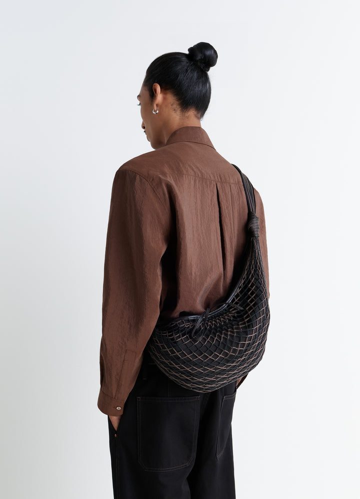 Lemaire Croissant Filt Bag in Black Nylon Net, model shot, Back view Shown on shoulder