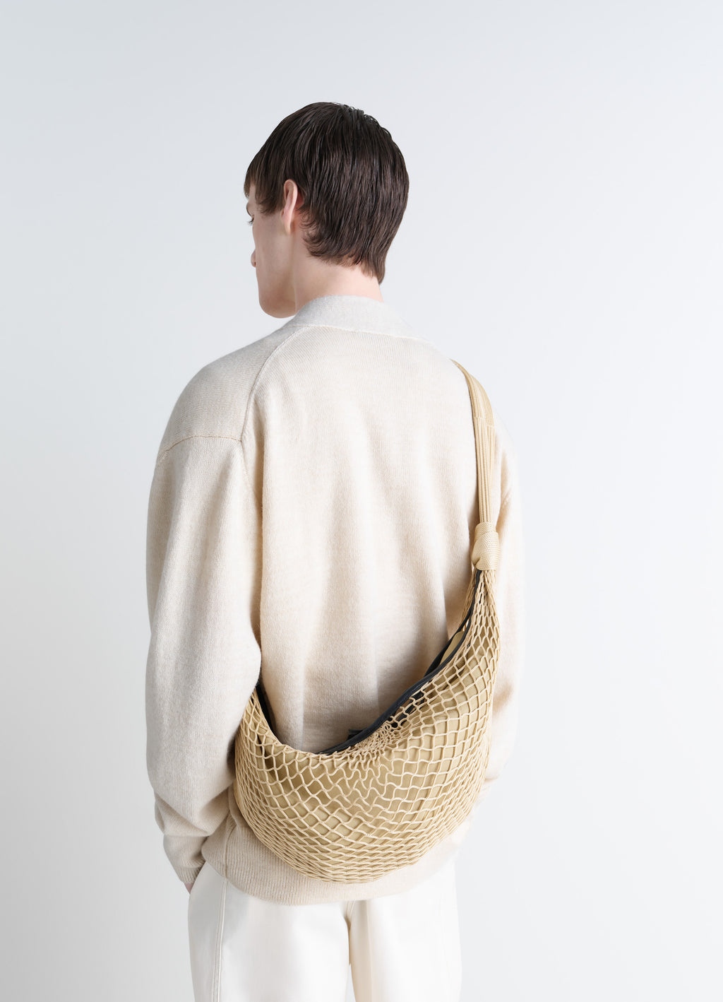 Lemaire Croissant Filt Bag in Beige Nylon Net, model shot, back view worn crossbody