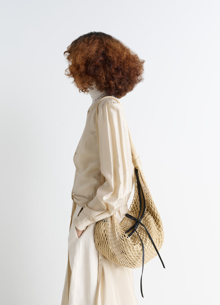 Lemaire Croissant Filt Bag in Beige Nylon Net, model shot, Side view With removable inner bag
