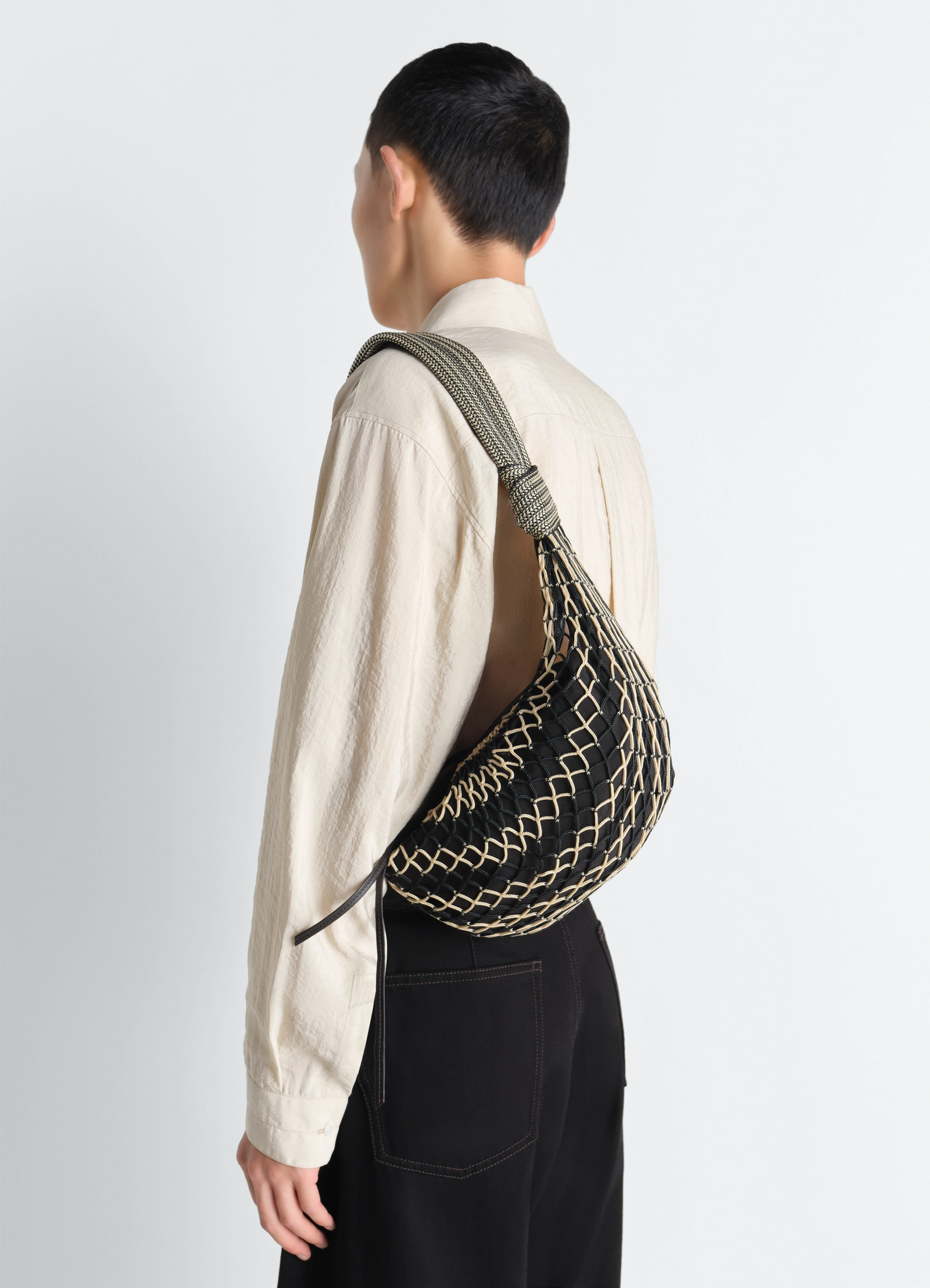 Fortune croissant filt bag in black nylon net, model shot, back view woven net texture