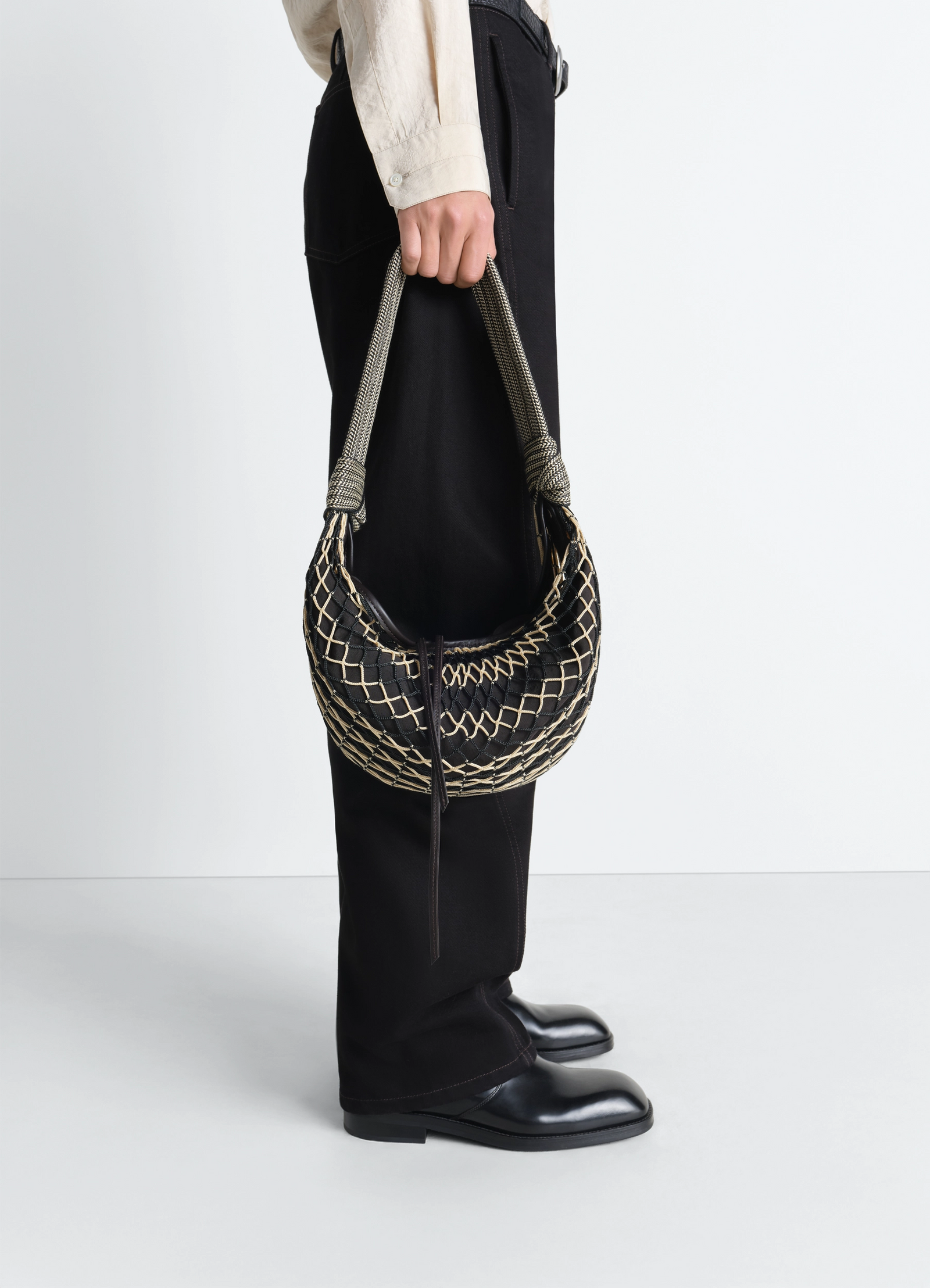 Fortune croissant filt bag in black nylon net, model shot, side view woven rope handle