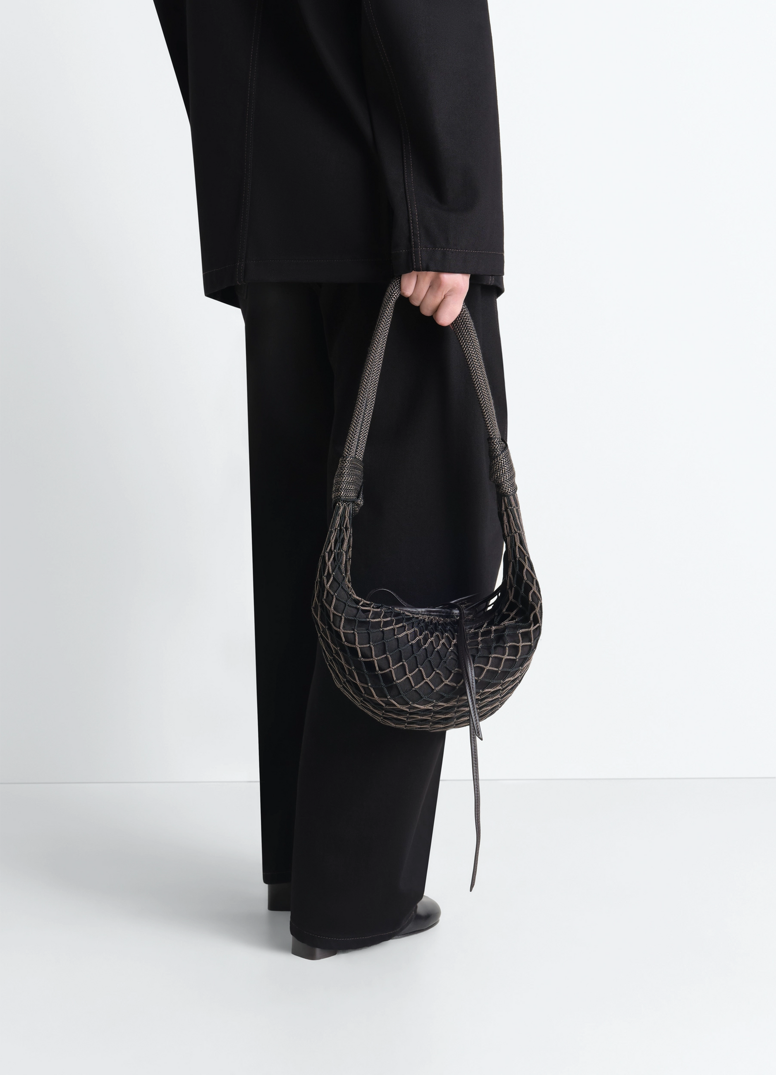 Fortune croissant filt bag in black nylon net, model shot, side view woven pattern handle