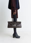 Lemaire Shoulder Gear Bag in Dark Brown Vegetable-Tanned Leather, model shot, Side view Flap closure with metal clip